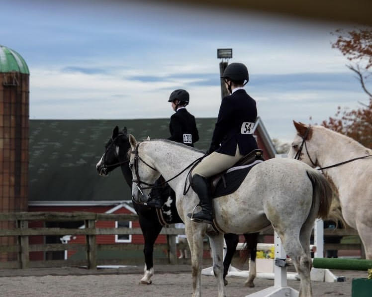 two members of the equestrian team on horseback