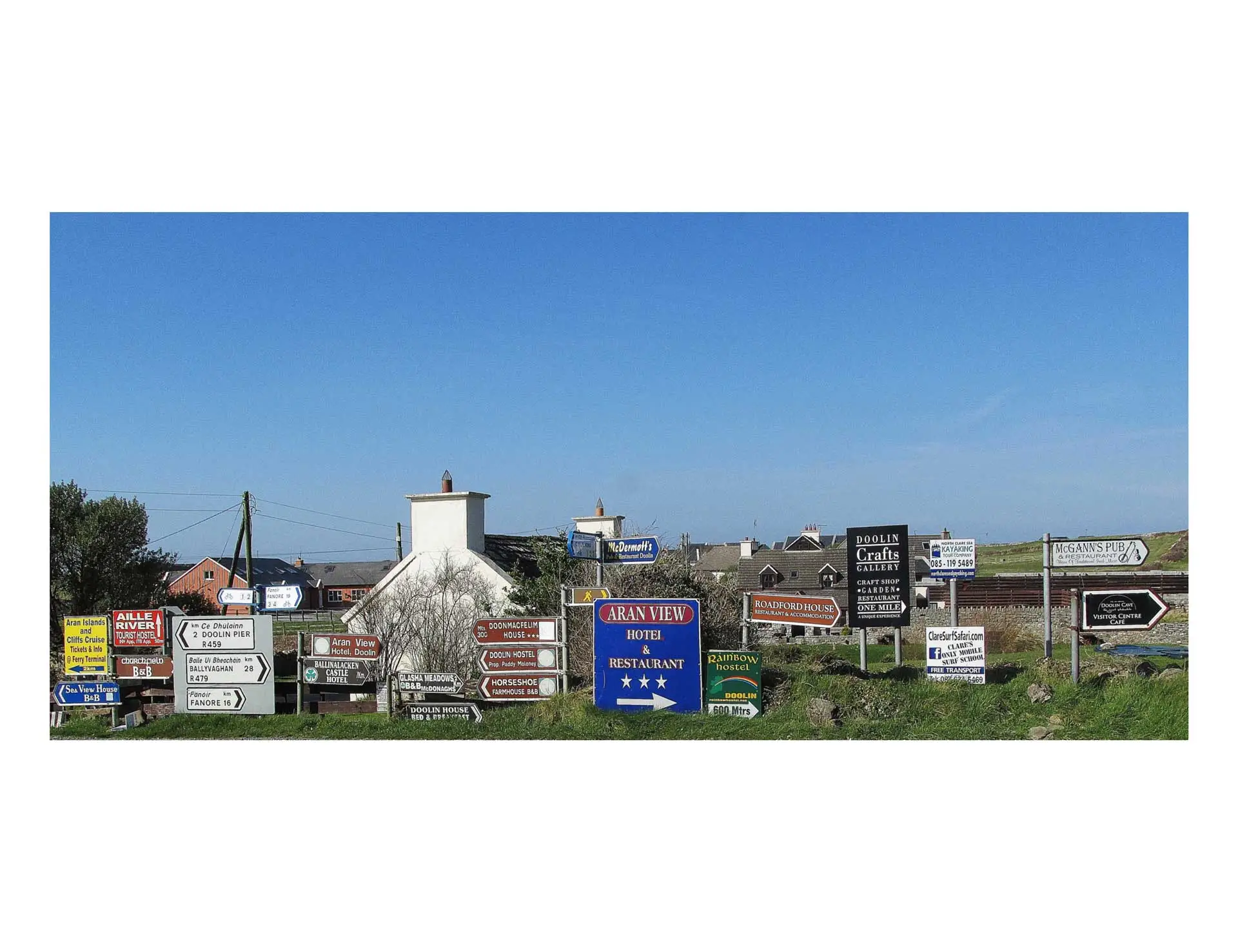 a photo of a roadside with numerous directional signs