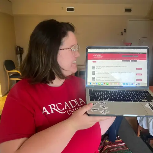 Jo Creollo '24 holds a laptop open to the Office of Career Education website