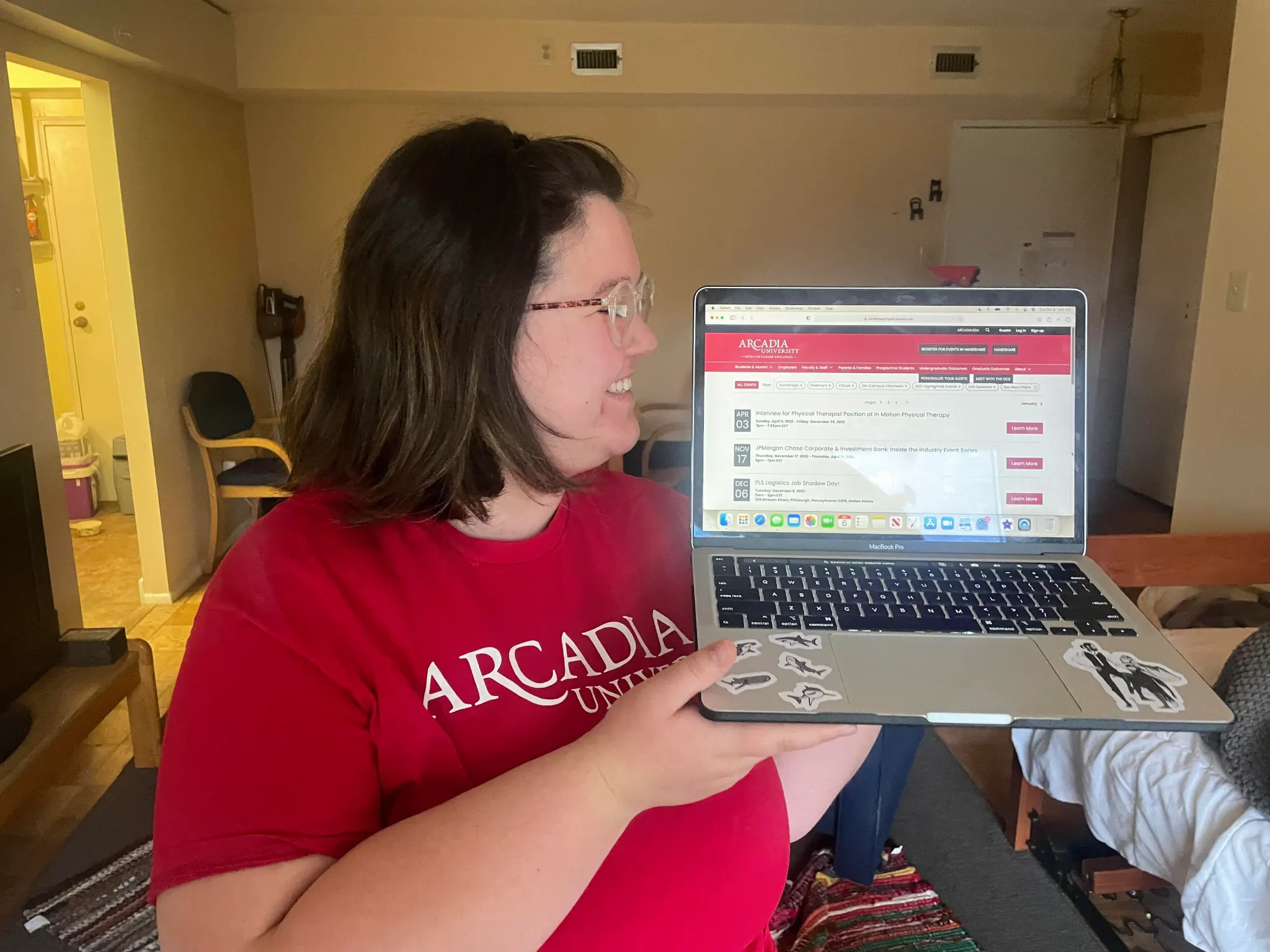 Jo Creollo '24 holds a laptop open to the Office of Career Education website