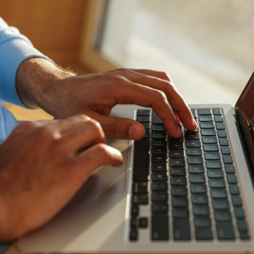 Hands typing on computer keyboard.