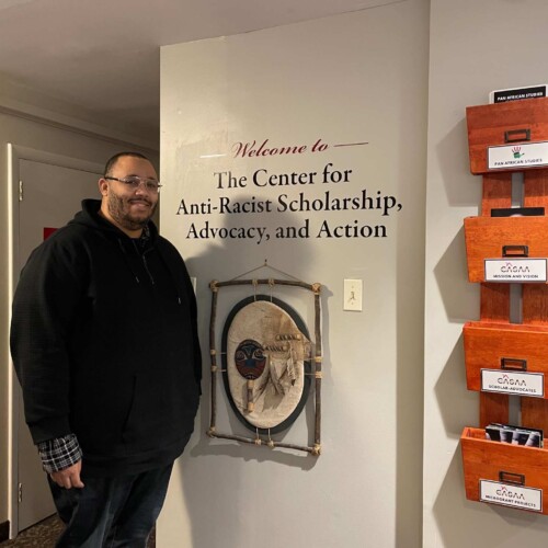 Christopher Varlack standing in the entryway of the Center for Anti-Racist Scholarship, Advocacy, and Action