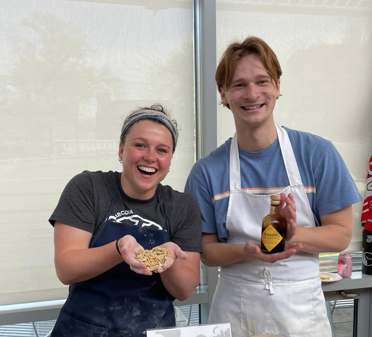 Two students hold the ingredients for a pasta dish at the Italy table at Global Expo