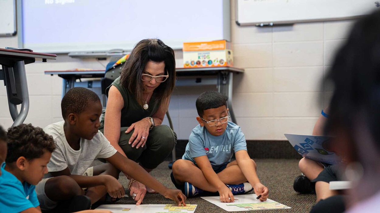 A teacher interacting with children in a classroom