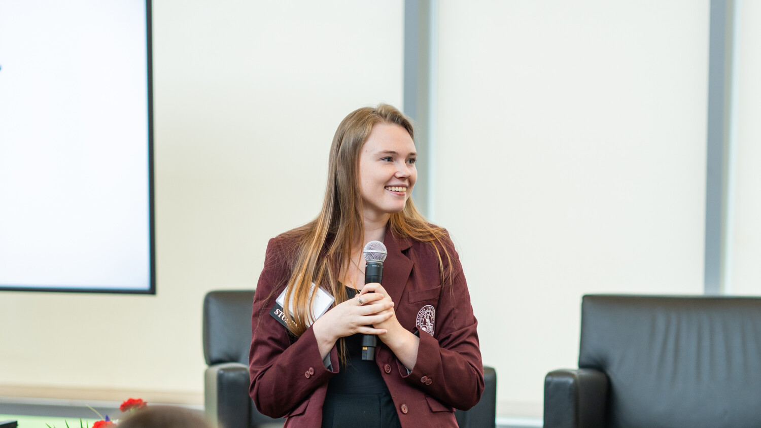 A speaker holds a microphone during the Women Who Lead Forum 2024 at Arcadia University.