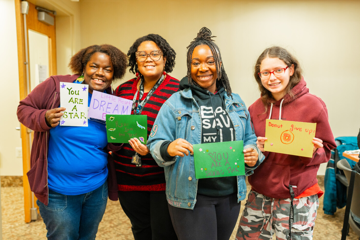 Four students showing their cards creating on Martin Luther King Jr. Day