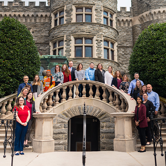 The Physician Assistant faculty stand over the stairway outside of Grey's Castle.