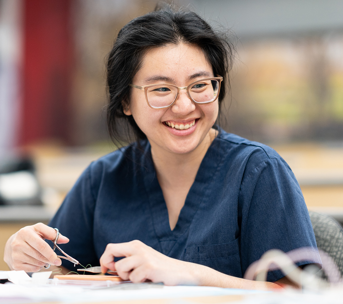 A PA student uses medical string and other supplies during class.