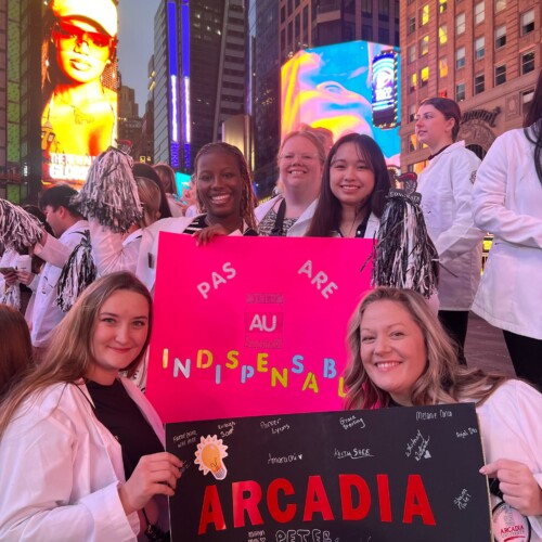 A group of PA students from the Class of 2026 take a selfie holding signs saying "PAs are indispensible" and "Arcadia 2026"