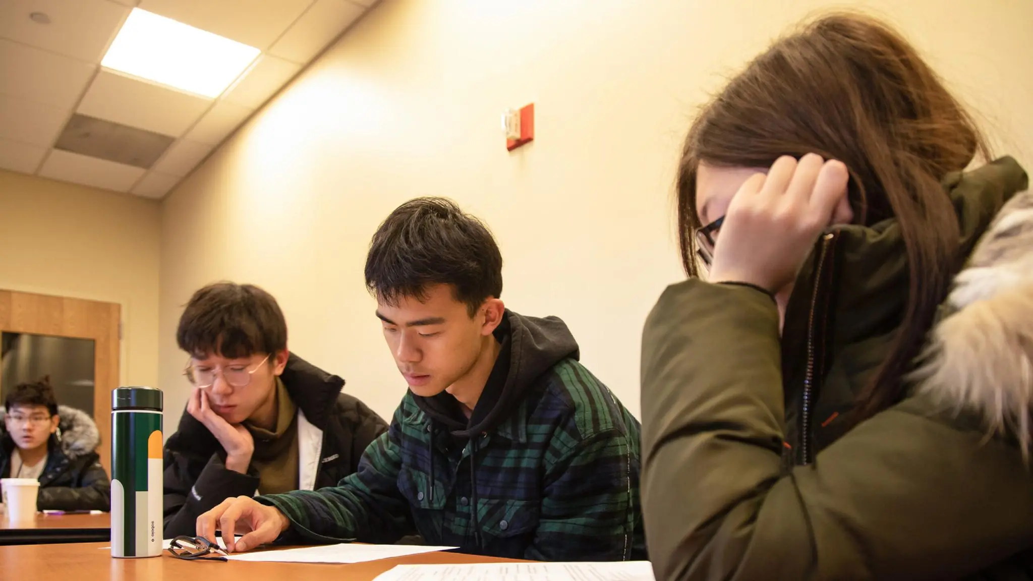 International students work on paperwork in a classroom.