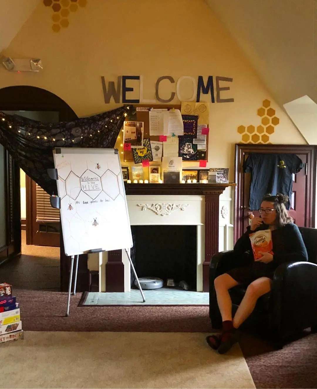 A student sits in a chair and eats while in The Hive.