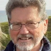 Dr. Colin A. Ireland closeup with mountainous landscape in the background