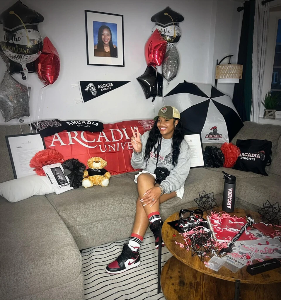 Jamai sitting on a couch covered in Arcadia gear.